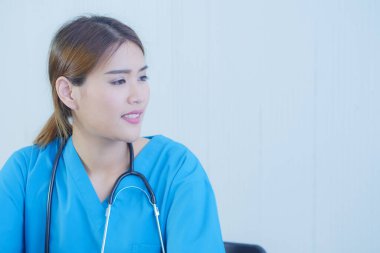 Steteskoplu mavi üniformalı Asyalı kadın doktor portresi..