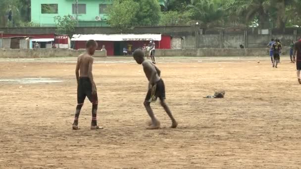 ギニア共和国コナクリ エボラ熱荒れ狂う 外サッカー アフリカの細身の男の子 — ストック動画