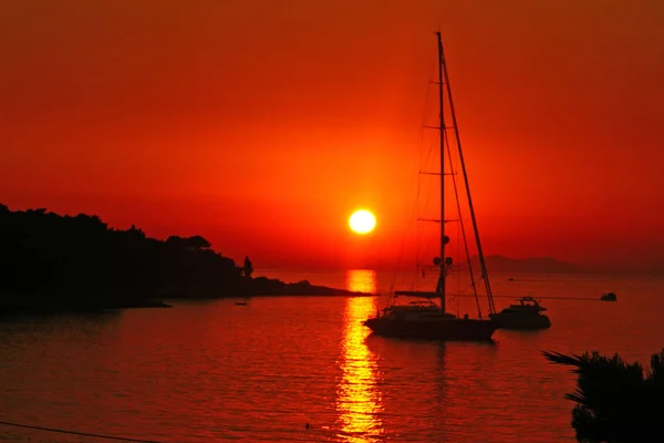 Puesta de sol en el mar con barco y costa — Foto de Stock