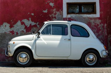 İtalya 'nın eski kasabasında küçük dar bir sokakta küçük beyaz bir araba duruyor.