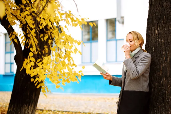 Creative woman in autumn park drinking take away coffee — Stock Photo, Image