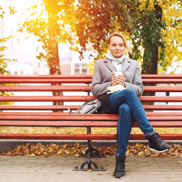 Стильная Женщина Сидящая Скамейке Кофе Бумажной Тетрадью Осенний Солнечный День — стоковое фото