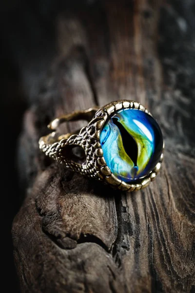 Bague créative avec oeil de dragon sur fond en bois — Photo