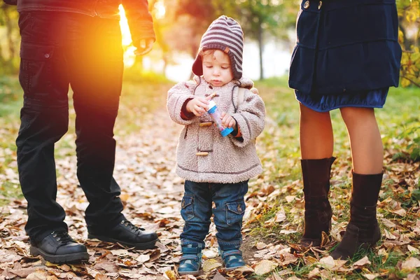 Mignon enfant de deux ans en vêtements chauds debout parmi ses parents — Photo