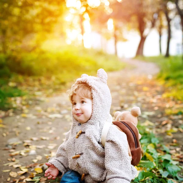 Cute funny toddler in autumn park having fun — Stock Photo, Image