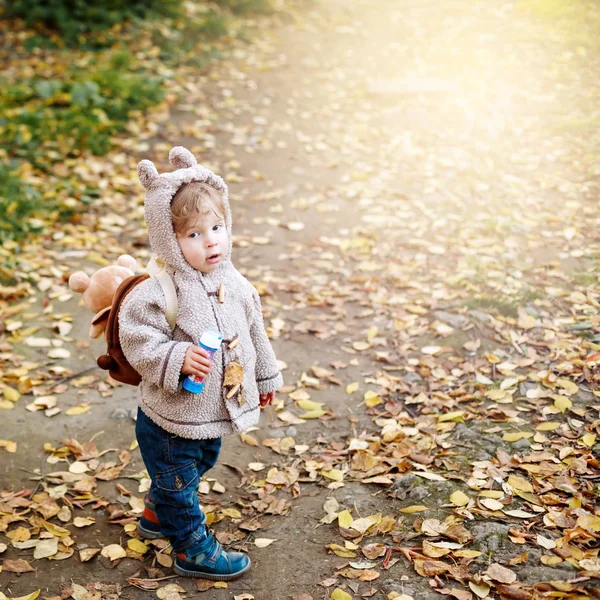 Cute funny toddler in autumn park having fun — Stock Photo, Image