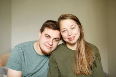 Gün ağarırken evde birlikte oturan, gündelik giysiler içinde yorgun ve güzel evli bir çiftin yakın plan portresi.