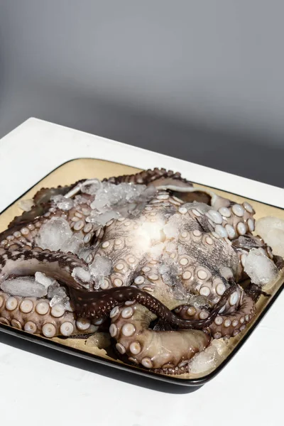 一整盘生的大章鱼 放在冰上准备好 从上往下看 — 图库照片