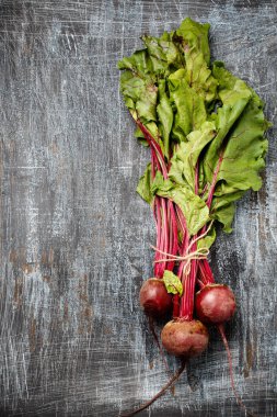 Bir demet taze organik çiftçi genç pancar kökleri koyu renkli arka plan, üst manzara. Doğal organik sebzeler.