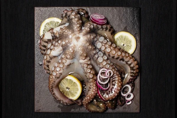 一整盘生的大章鱼 配上柠檬和红洋葱准备烹调 从上方看 — 图库照片