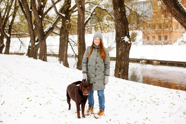 겨울에는 기르는 노동자와 눈덮인 공원에서 산책을 여성에게 미소짓는 — 스톡 사진