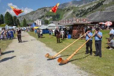 Engstlenalp, İsviçre - 4 Ağustos 2018: alphorn ve bayrak taşıyıcılar Engstlenalp İsviçre Alpleri üzerinde oynayanlar