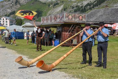 Engstlenalp, İsviçre - 4 Ağustos 2018: alphorn ve bayrak taşıyıcılar Engstlenalp İsviçre Alpleri üzerinde oynayanlar