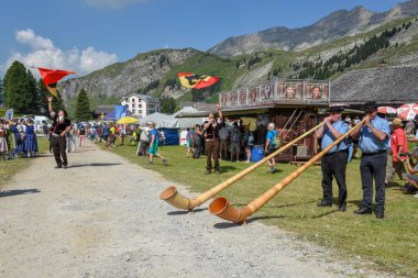 Engstlenalp, İsviçre - 4 Ağustos 2018: alphorn ve bayrak taşıyıcılar Engstlenalp İsviçre Alpleri üzerinde oynayanlar