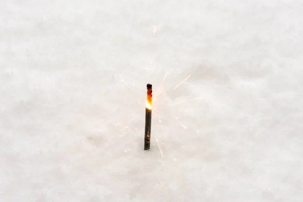 在雪地上燃烧闪闪发亮的棍子 — 图库照片
