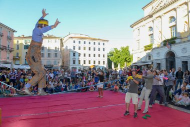 Lugano, İsviçre - 15 Temmuz 2016 - Lugano, İsviçre Buskers Festivali'nde insanlar tarafından desteklenen slackline üzerinde yürüyen adam