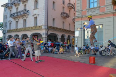 Lugano, İsviçre - 15 Temmuz 2016 - Lugano, İsviçre Buskers Festivali'nde insanlar tarafından desteklenen slackline üzerinde yürüyen adam