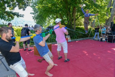 Lugano, İsviçre - 15 Temmuz 2016 - Lugano, İsviçre Buskers Festivali'nde insanlar tarafından desteklenen slackline üzerinde yürüyen adam