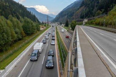 Airolo, Switzerland - 30 September 2018: vehicles waiting in line for entering Gotthard tunnel on the Swiss alps clipart