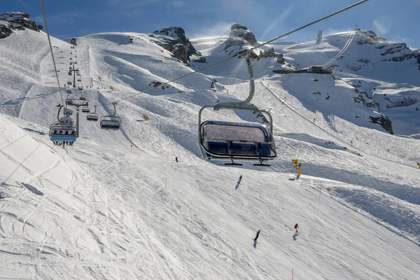 Люди катаются на лыжах и поднимаются на гору на подъемнике в Энгельбере — стоковое фото