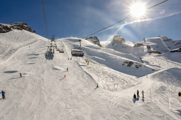 People skiing and going up the mountain by chairlift at Engelber — Stock Photo, Image