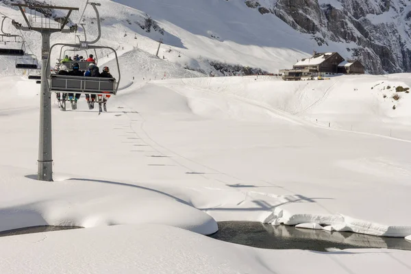 People skiing and going up the mountain by chairlift at Engelber — Stock Photo, Image