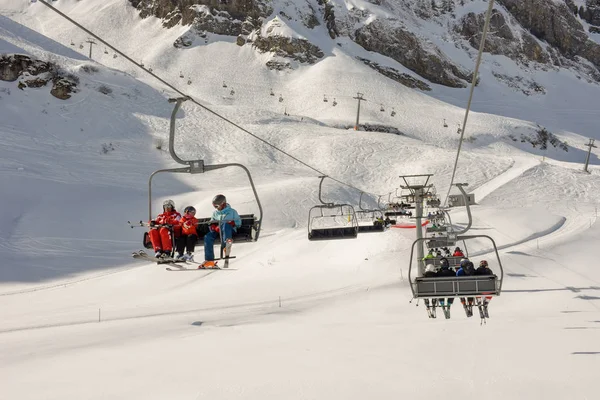 People skiing and going up the mountain by chairlift at Engelber — Stock Photo, Image