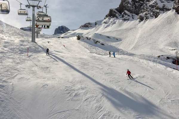 Gente esquiando y subiendo la montaña en telesilla en Engelber — Foto de Stock