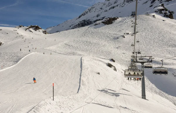 Gente esquiando y subiendo la montaña en telesilla en Engelber — Foto de Stock