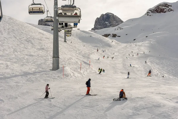 La gente sciare e salire la montagna in seggiovia a Engelber — Foto Stock