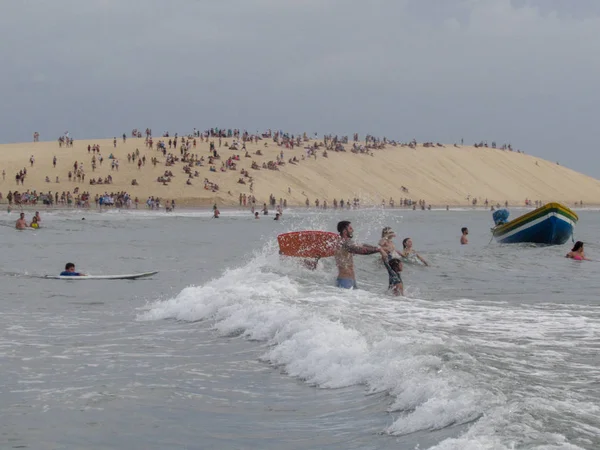 Människor sitter på dyn Jericoacoara att se solnedgången — Stockfoto