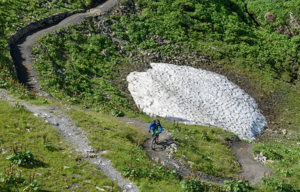 L'uomo sulla sua mountain bike scendendo il sentiero da Jochpass oltre — Foto Stock