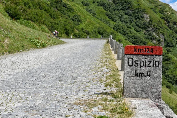 Ciclistas a lo largo de la antigua carretera del monte Gotthard en los Alpes suizos — Foto de Stock