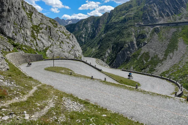 Ciclistas a lo largo de la antigua carretera del monte Gotthard en los Alpes suizos — Foto de Stock