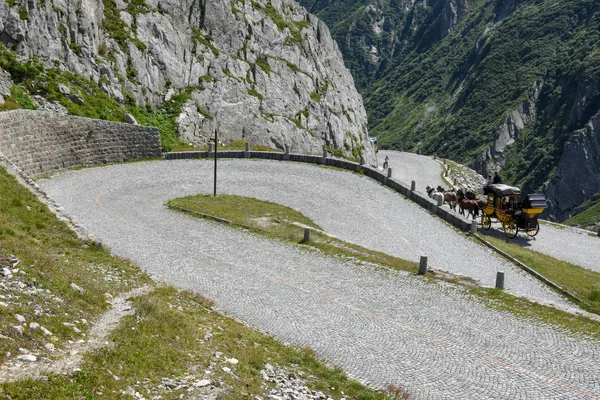Caballo carruaje dibujado a lo largo de la antigua carretera del Monte Gotthard en el — Foto de Stock