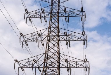 Yüksek voltajlı elektrik iletim kulesi teller ve izolatörler karşı bulutlar ile orta kısmı.