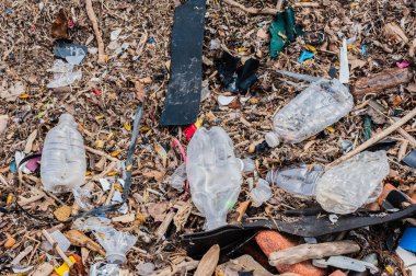 Rasgele plastik, atık, çöp, enkaz ve tuğlalar yere dağılmış.