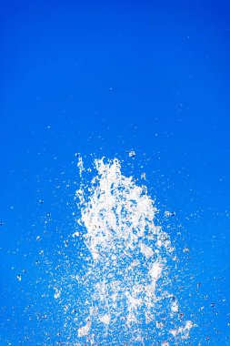 Soyut ışıklı su çeşme sıçrama açık mavi gökyüzü karşı.