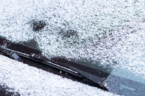 Snow covered car window, macro, close up. Antifreeze was not used. Vehicles in snow. Winter time is coming. Bad weather conditions