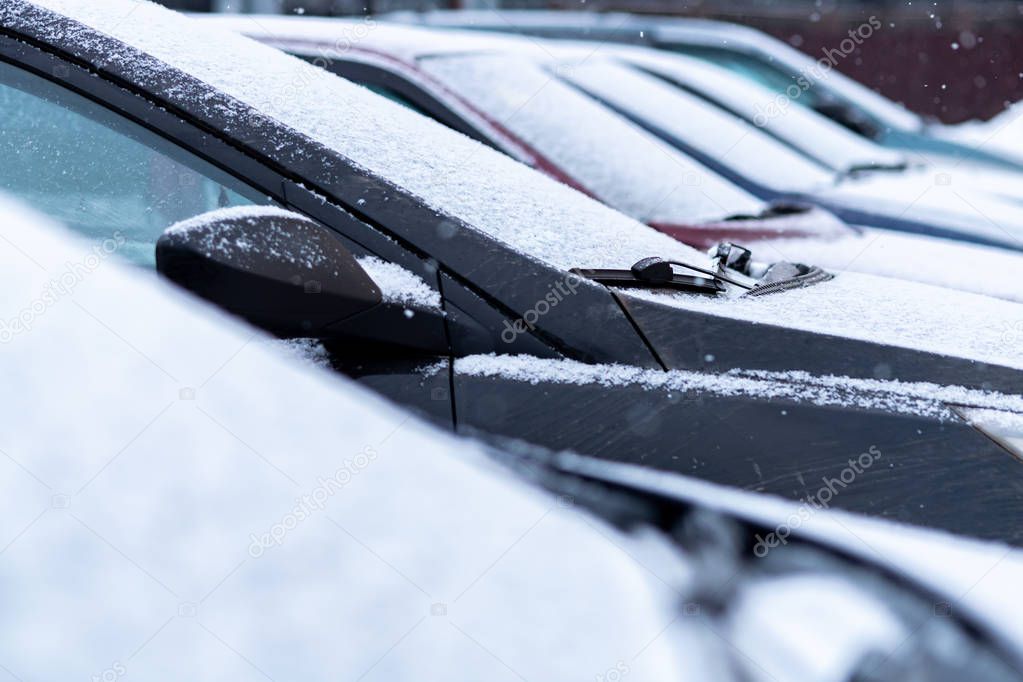 Snow covered cars in the parking, close up. Antifreeze was not used. Vehicles in snow. Winter time is coming. Bad weather conditions