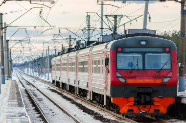 Elektrikli Tren demiryolu hattında gider. Tren yolcu taşımaktadır. Kış seyahat etmek.