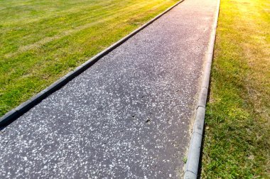 Kaldırım manikürlü Çim mowed ışık ile kamu Park arasında flare.