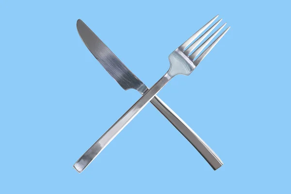 銀光沢のあるフォークとナイフを渡った 分離された青い背景 コンセプト デザインを破るための時間 コピー スペース — ストック写真