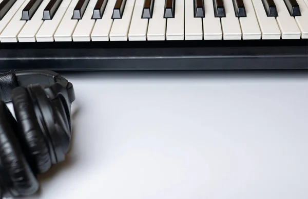 Piano keys and headphones with copy space, isolated. Synthesizer