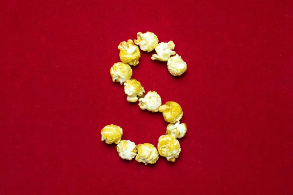 Английский алфавит из кинопопкорна. Буква С. Красный фон f — стоковое фото