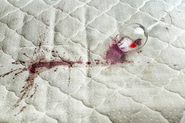 Wine glass spilled on bed. Dropped wineglass on white bed sheet. — 스톡 사진