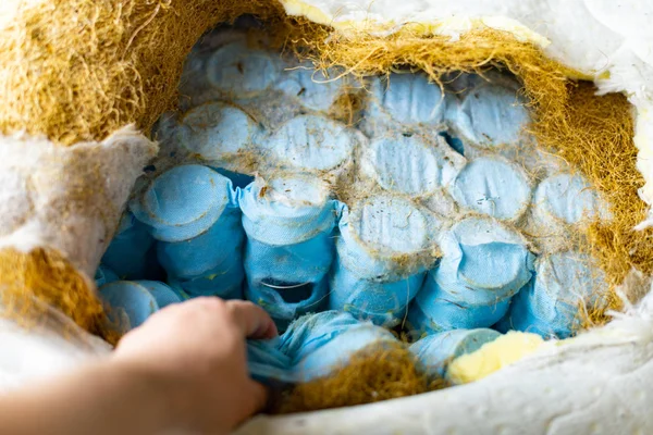 Bed vuller en veren in oude bed matras met zachte kokos vuller. Bed of Bank reparatie en herstel voor goed slapen. Veren in matras vervangen. — Stockfoto