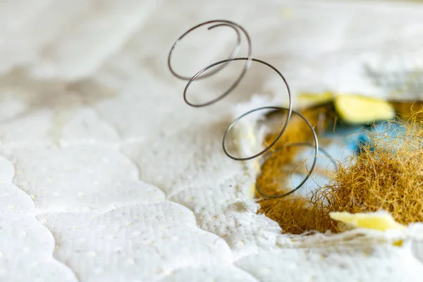 Lente in oude bed matras met pillen. Gat in oude vuile lekkende Bank, noodzaak van reparatie of vervanging. — Stockfoto