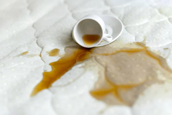 Spilled cup of tea on the bed. Accidentally dropped cup with sau — Stock Photo, Image