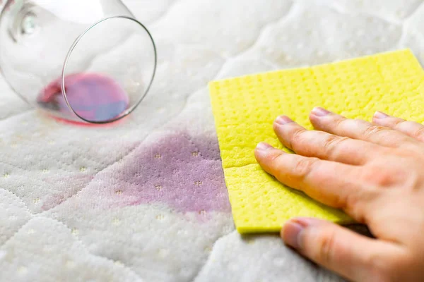 Sponge cleaning wine stain. Dropped wineglass. Spilled wine on w — Stock Photo, Image